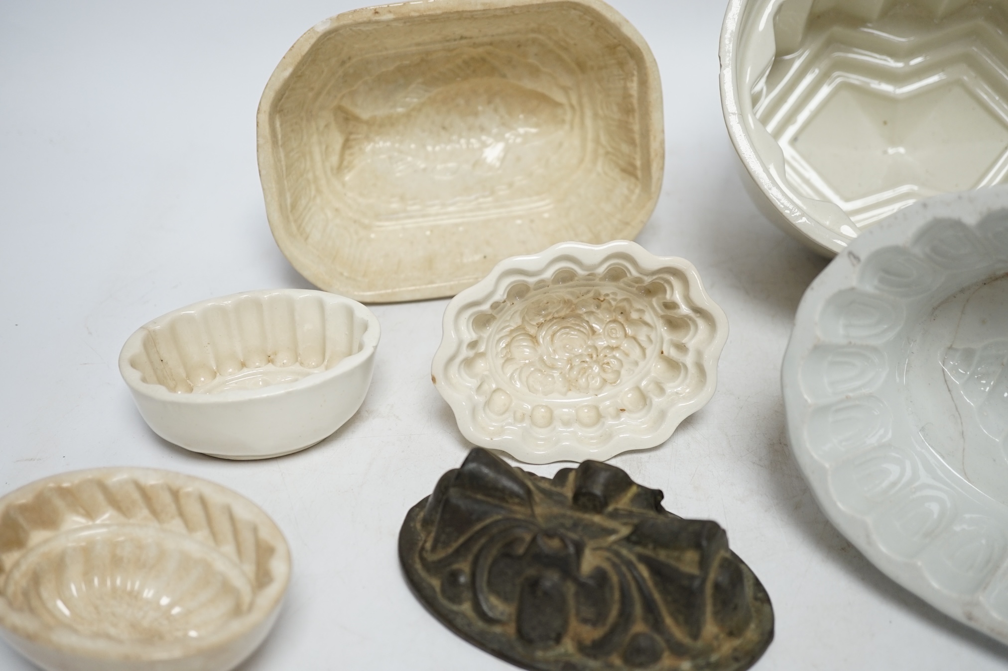 From the Studio of Fred Cuming. Seven jelly moulds including six ceramic examples, one Cetemware, largest 17cm wide. Condition - fair, one cracked